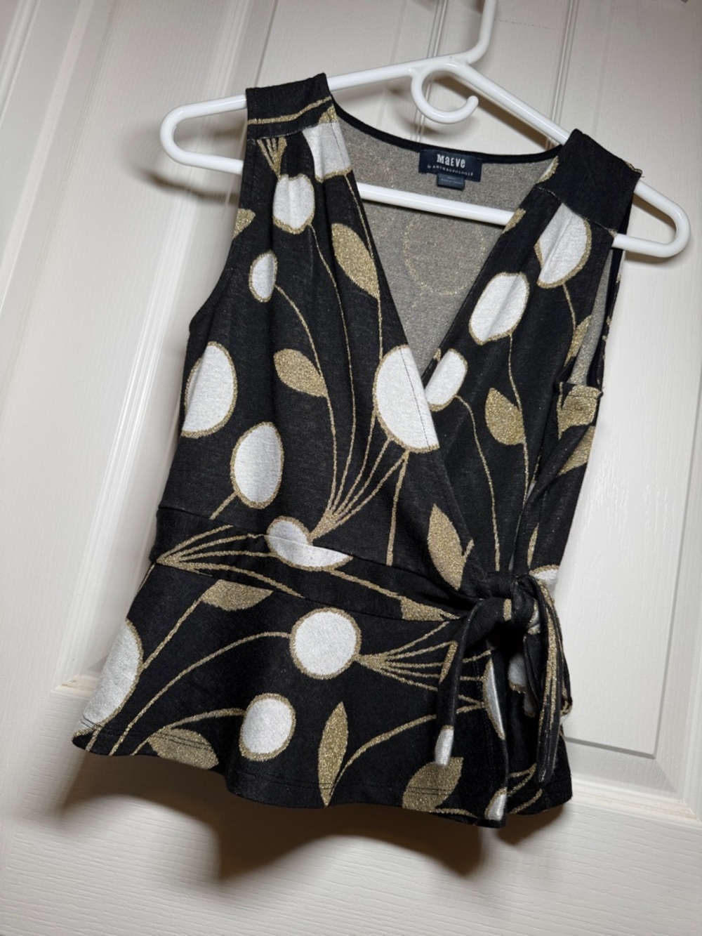 Anthropologie Black Sleeveless Wrap Top with Gold and White Floral Accents